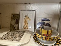 Microwaveable hot plate trivet with granite center, giraffe-themed mug, bowl, plate set by Multiple Choice, vintage 1975 Fitz & Floyd giraffe wall hanging framed artwork, and vintage car trivet