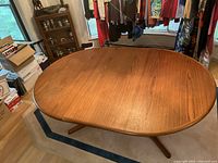 Top-down view of oval teak tabletop with one leaf inserted