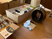 Nescafé Dolce Gusto coffee machine and some manuals on wooden floor.