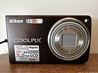 Front view of Nikon Coolpix S550 showing lens and camera branding with specs sticker.