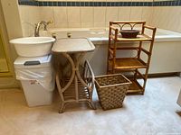 Wide shot showing the full lot of items placed along a bathroom floor including basin and garbage cans