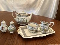 Overall view of tea set on tray with creamer, sugar bowl, and salt and pepper shakers showing pattern and condition.