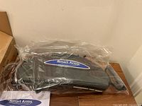 Smart Arms arm exerciser packaged in plastic with visible logo