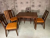 Full view of table with four chairs in basement setting