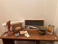 Full lot on wooden table: carved wood sculpture, torch replica box and sleeve, flower bouquet box, small boxes, decorative tin, candle box