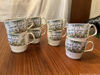 Eight Royal Albert Silver Birch coffee cups grouped on wood table.