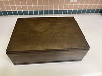 Closed dark wooden chest holding the silverware set