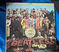 Front cover of The Beatles Sgt. Pepper's Lonely Hearts Club Band vinyl album showing the multicolored collage of famous figures around the band name spelled out in flowers.