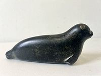 Side view of black stone seal carving showing form and polished surface.