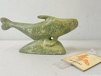 Side view of the green stone seal carving showing the base and profile of the seal.