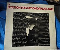 Front cover of the David Bowie Station To Station vinyl LP album, showing black and white photo of Bowie and red text.