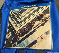 Front cover photo of The Beatles 1967-1970 vinyl LP album showing the band members looking down from a balcony. The album cover has visible wear.