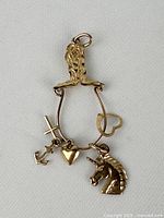 Front view of 10K gold pendant showing four dangling charms