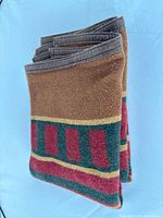 Folded blanket showing stripe pattern and grey edging