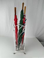 Three umbrellas standing in white metal stand