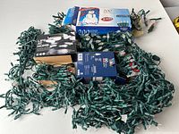 Overview of multiple boxed and loose green-wire string lights