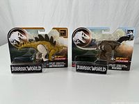 Both packaged dinosaur figures side by side
