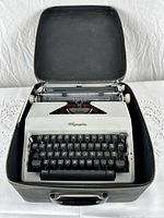 Typewriter seated inside its open hard shell carry case