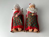 Both figurines in beds with quilts and pillows