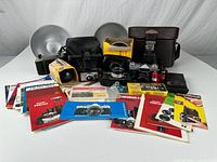 All items grouped: cameras, cases, flash units, reflectors, manuals, bulbs