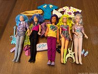 All five dolls laid out with guitars, shoes, extra clothes
