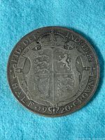 Obverse side of 1920 British Half Crown coin showing crowned shield and inscription.