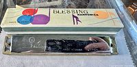 Photo showing the Blessing harmonica with original box, the box decorated with colorful musical notes and labeled 'Made in China'
