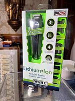 Photo showing front of the boxed WAHL Lithium Ion All-in-One Trimmer highlighting 3 hour run time, quick charge, and 4 attachment heads.