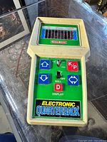 Front angled view of the COLECO Electronic Quarterback game showing the screen, directional control buttons, K/P button, skill switch, and display toggle.