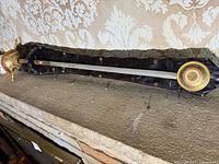 Full view of sabre mounted on dark wooden plaque, showing length and width