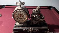 Full view of cast iron Ansonia mantel clock showing figure and case