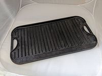 Full view of the rectangular cast iron grill griddle showing the ribbed surface and handles.