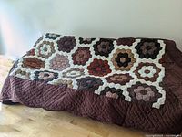 Full view of quilt draped over bed showing pattern and size