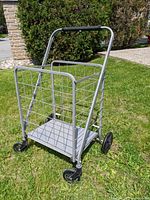 Metal shopping cart from front showing wire mesh basket, solid base, and front wheels
