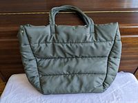 Photo of front side of the large olive green tote bag showing padded quilted stitching and dual handles.