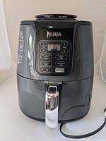 Front view of the black Ninja air fryer showing the overall unit and handle.