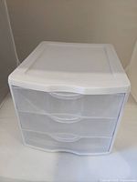 Front view of white plastic 3-drawer storage organizer in closed position