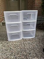 Two white plastic storage drawer units each with three drawers shown from front angle. Wheels are inside and detached.