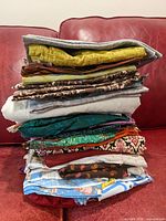 Stack of folded assorted fabrics showing multiple colors and styles.