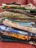 Stack of folded quilting fabrics in various colors and patterns