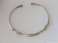 Full view of silver open cuff bracelet showing decorative inlays and end caps