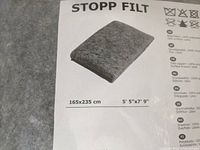Close-up of Ikea Stopp Filt rug underlay label showing dimensions and material details.