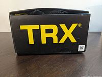 Closed black box with TRX logo in bold yellow letters on the side