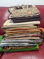 Stack of many upholstery fabric pieces of various patterns and colors placed together