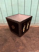 Full view of square tapered Chinese planter showing black lacquer with carved geometric borders and key ring handles on sides.