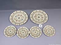 Six Copeland Spode Florence plates arranged, 2 larger and 4 medium, visible detailed floral design and scalloped edges.