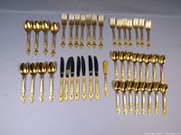 Image showing all 44 pieces of the flatware set including spoons, forks, knives, and a butter spreader arranged on a white surface.