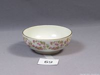Front view of the porcelain bowl showing floral decoration and gold rim.