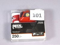 Petzl Tikkina 250 lumens headlamp in original clear plastic packaging with printed branding and specifications visible.
