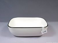 View of the white porcelain sink showing black rim and rounded rectangular shape from an angle.
